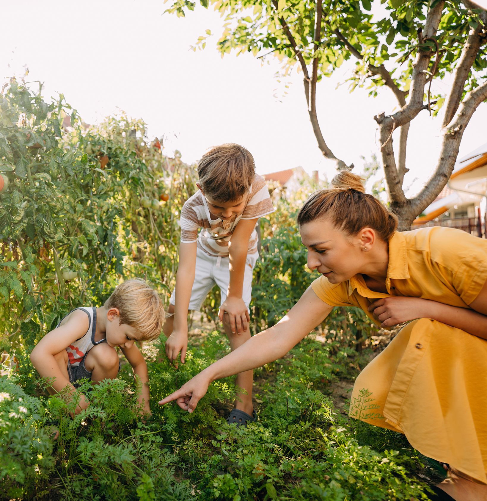 A mother and her children outside in their garden.