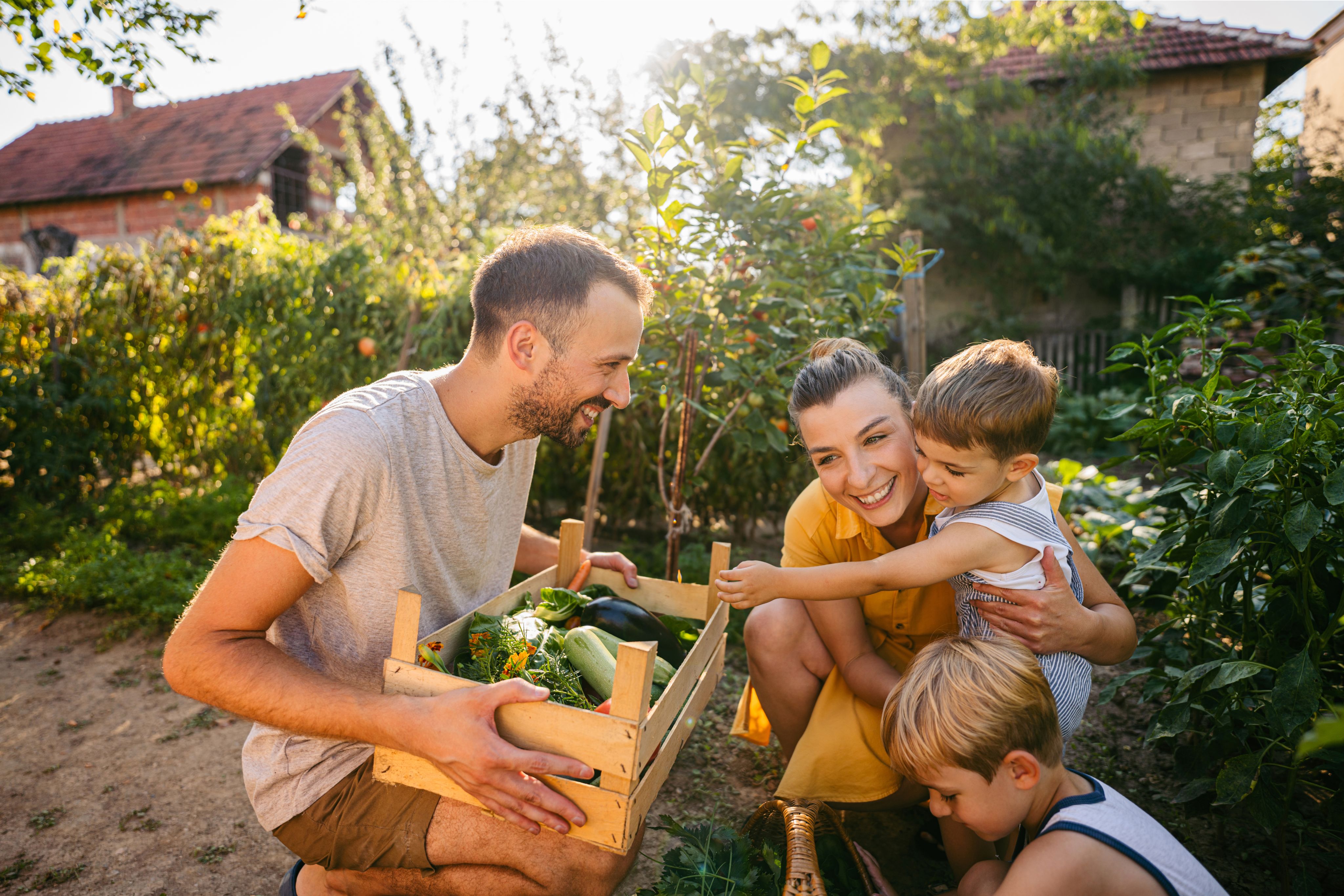 A family outside smiling in the sun in their garden.