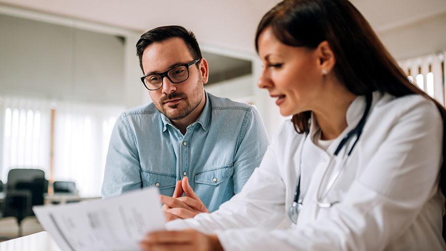 A man speaking with his doctor about his gout diagnosis and healthcare plan.