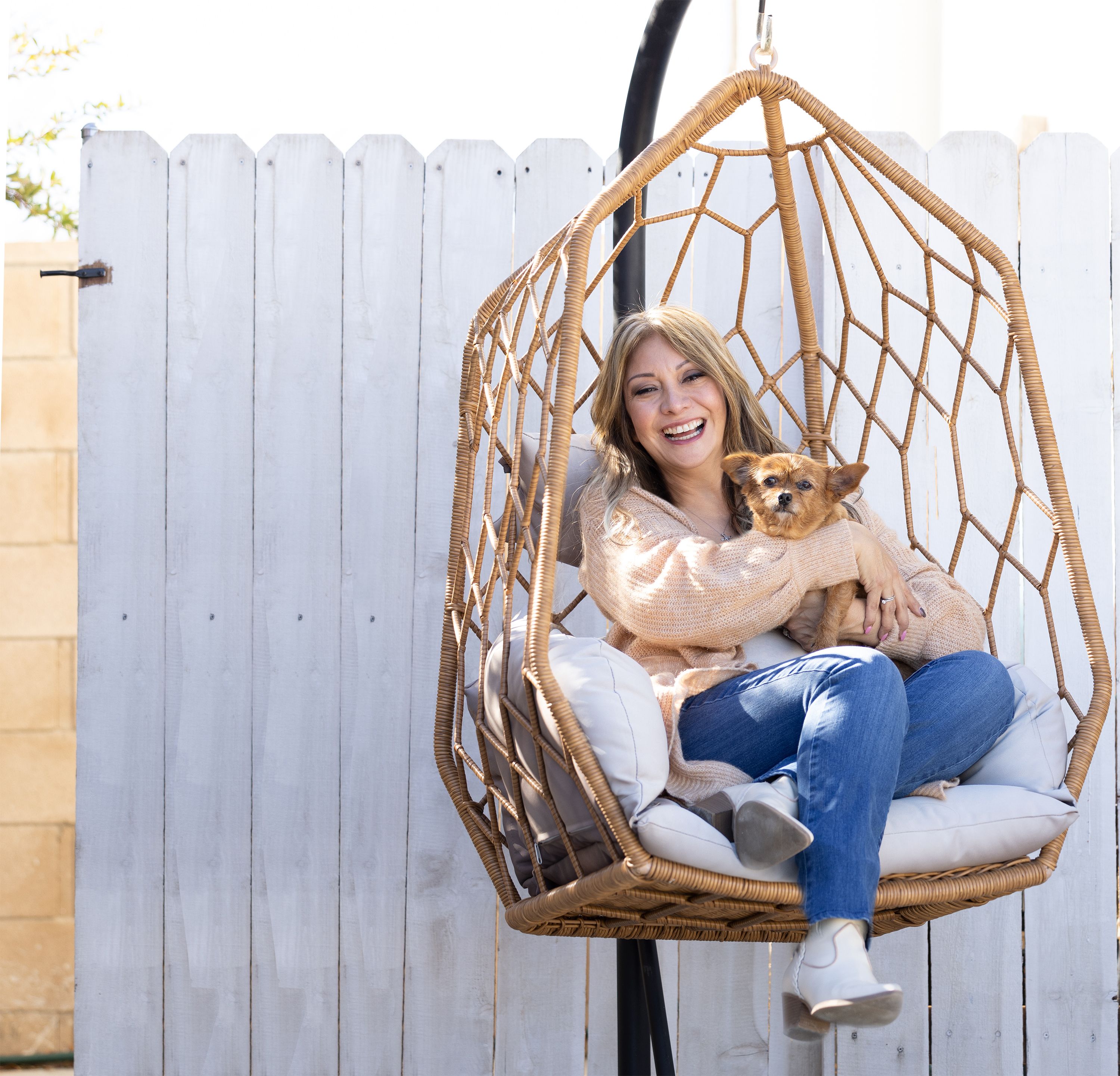 A woman smiling and sitting with her dog.