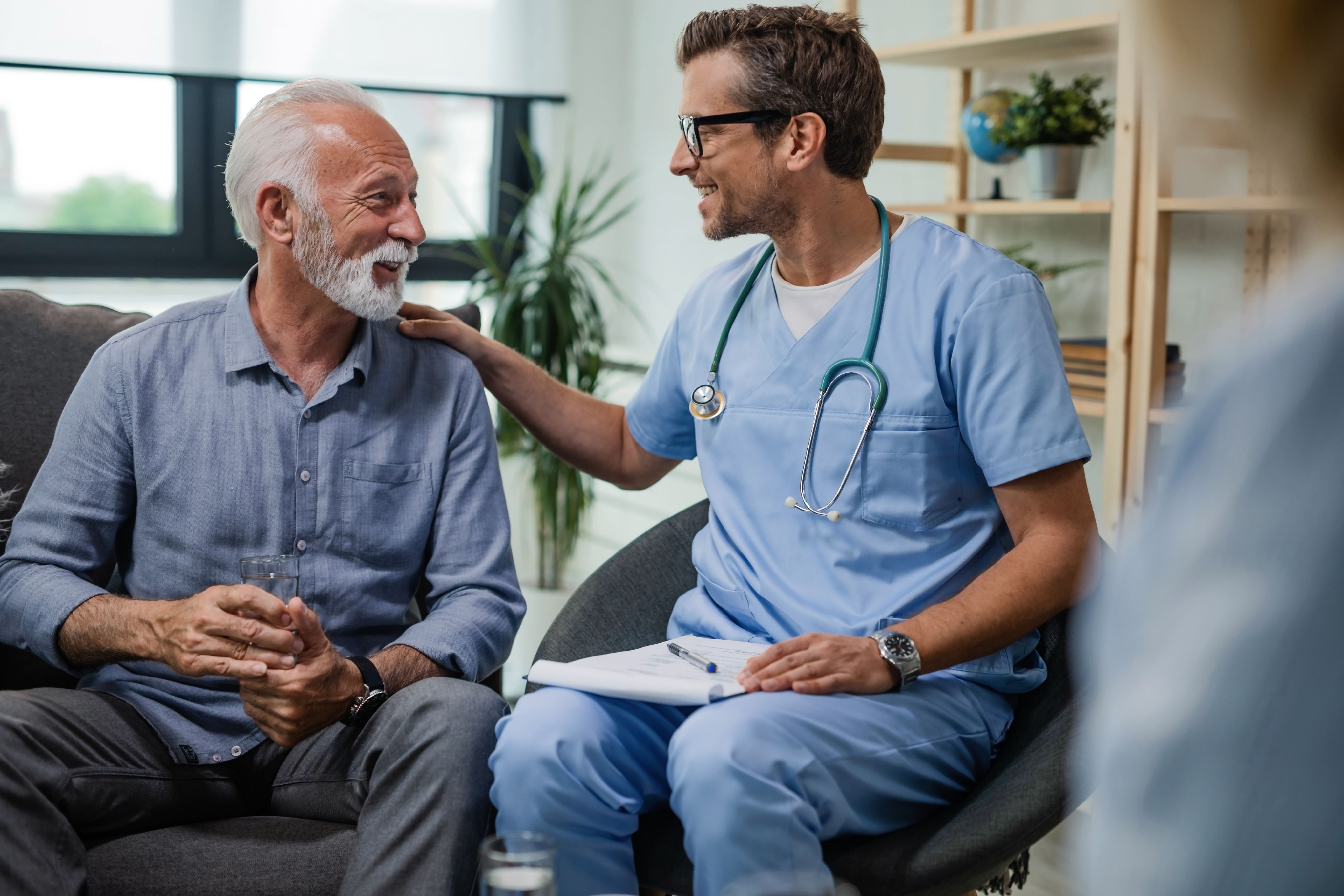 An older man with graves disease speaking with his doctor.