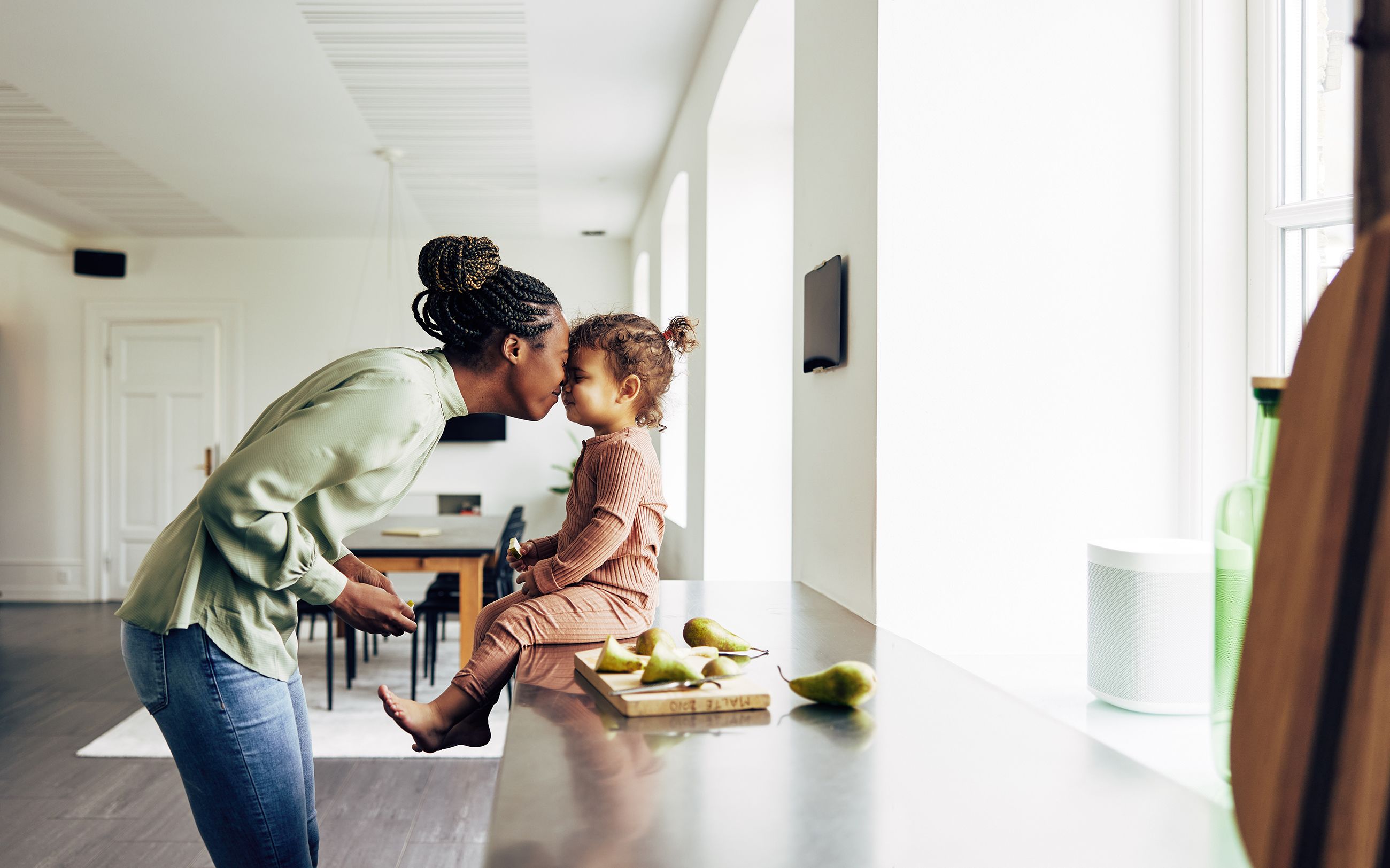 A mother and daughter laughing in the kitchen.