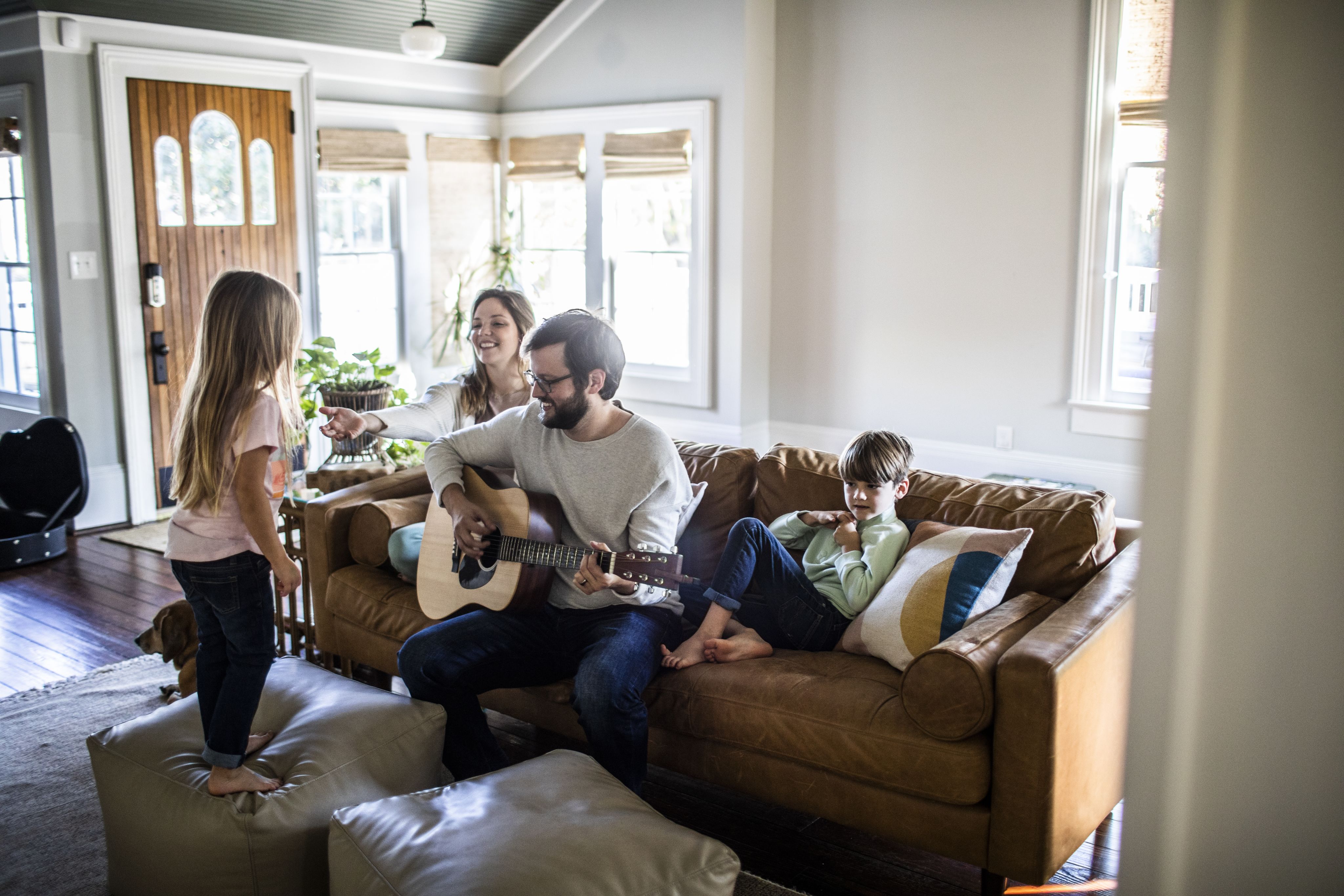 A happy healthy family playing music in the living room. 