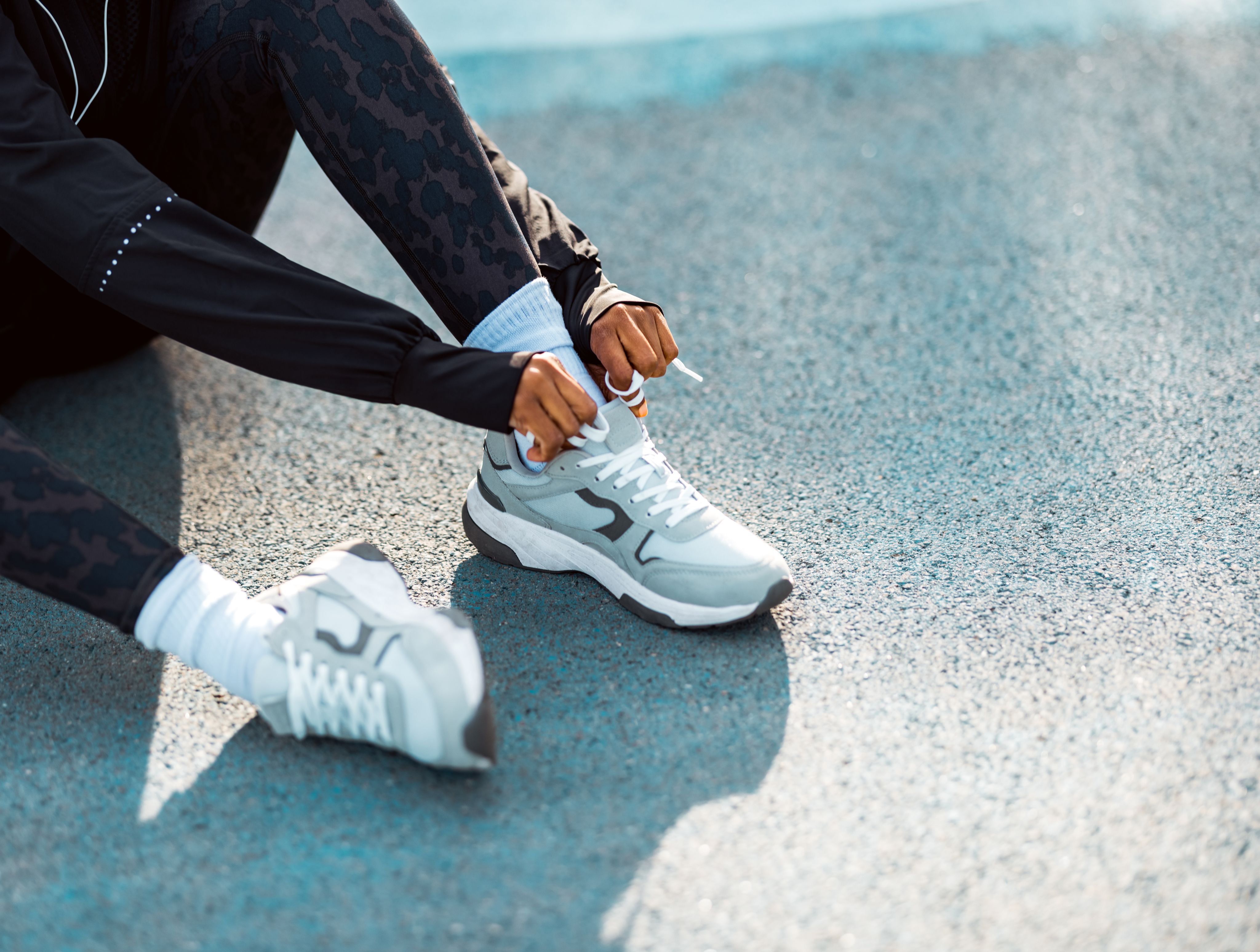 woman's hands tying running sneakers