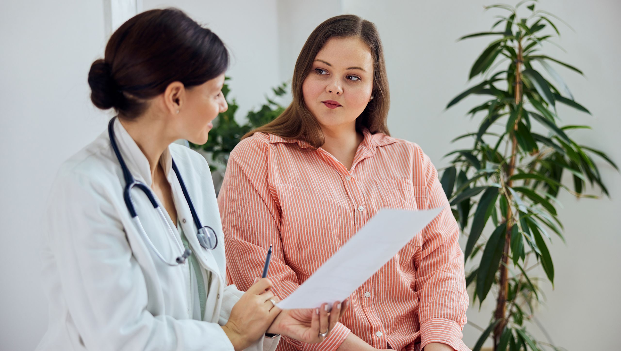 An image of a woman with graves disease smiling and speaking with her doctor.