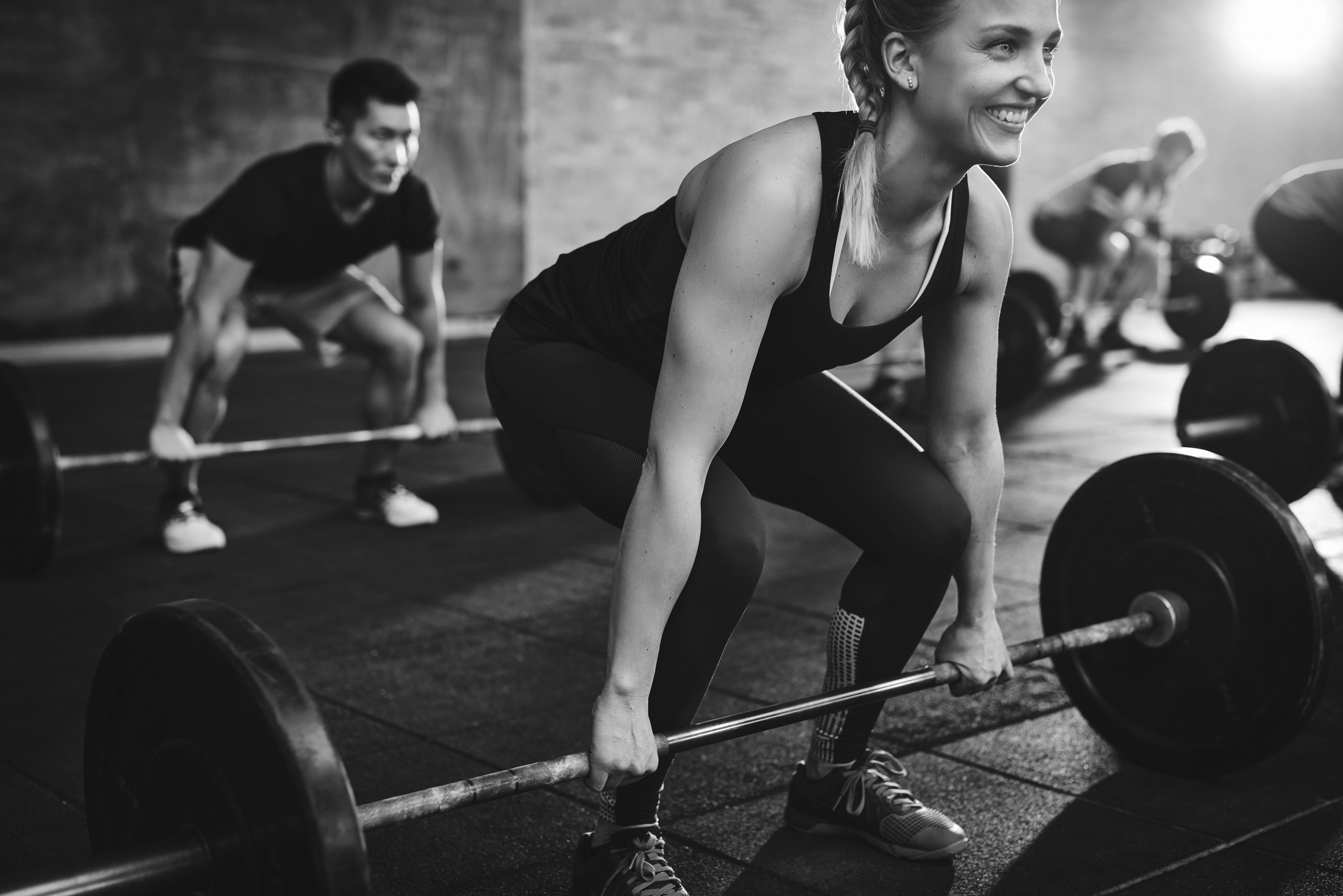 A woman heavy weight lifting in a workout class.