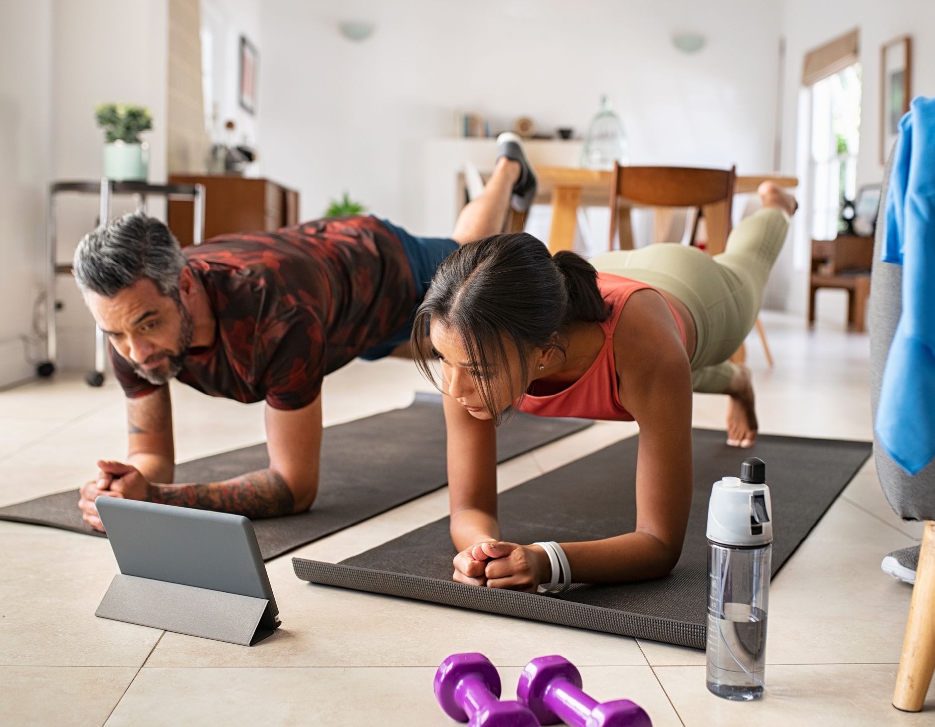 A couple practicing yoga at home.