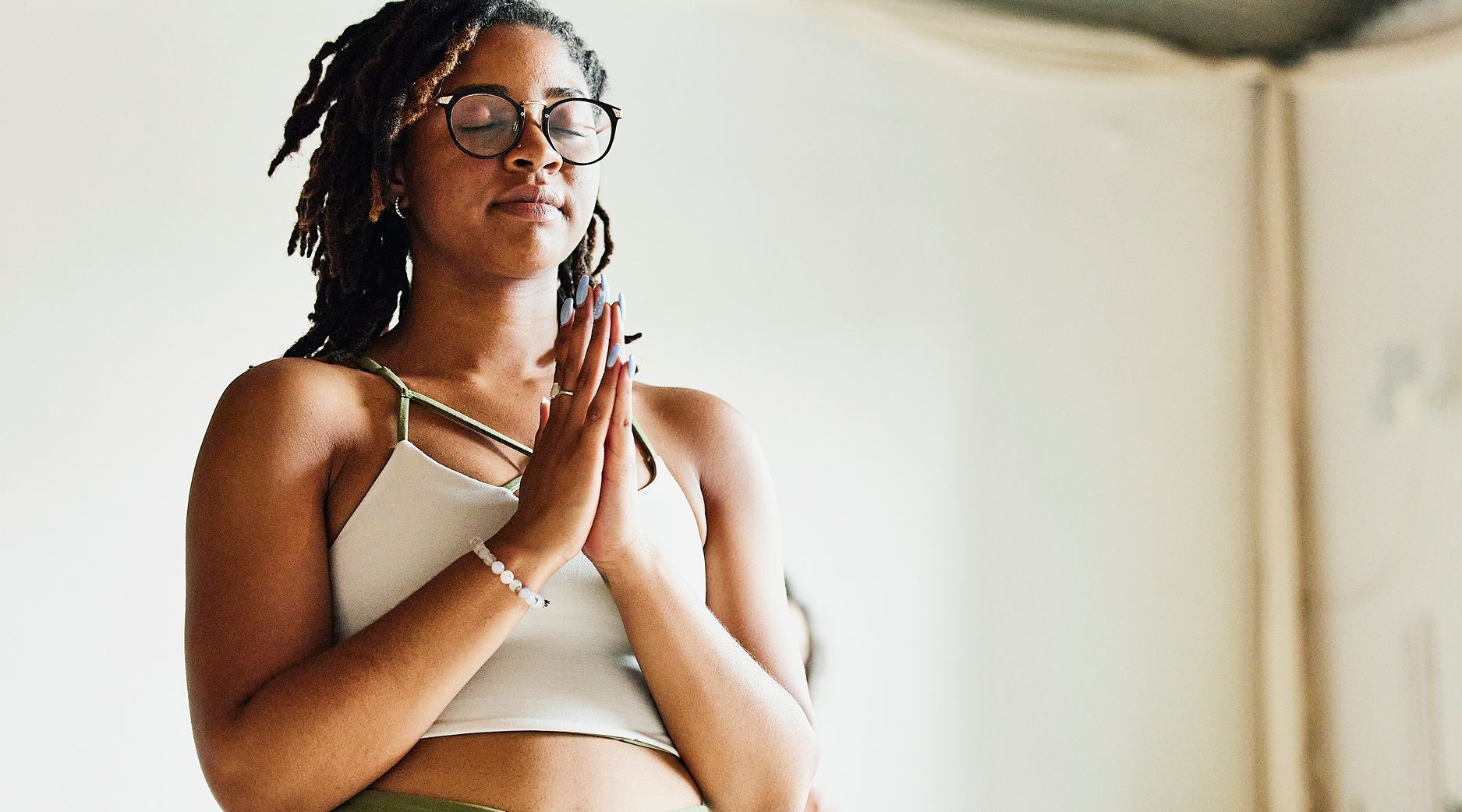 A person of color practicing yoga for lowered cholesterol and heart health benefits.