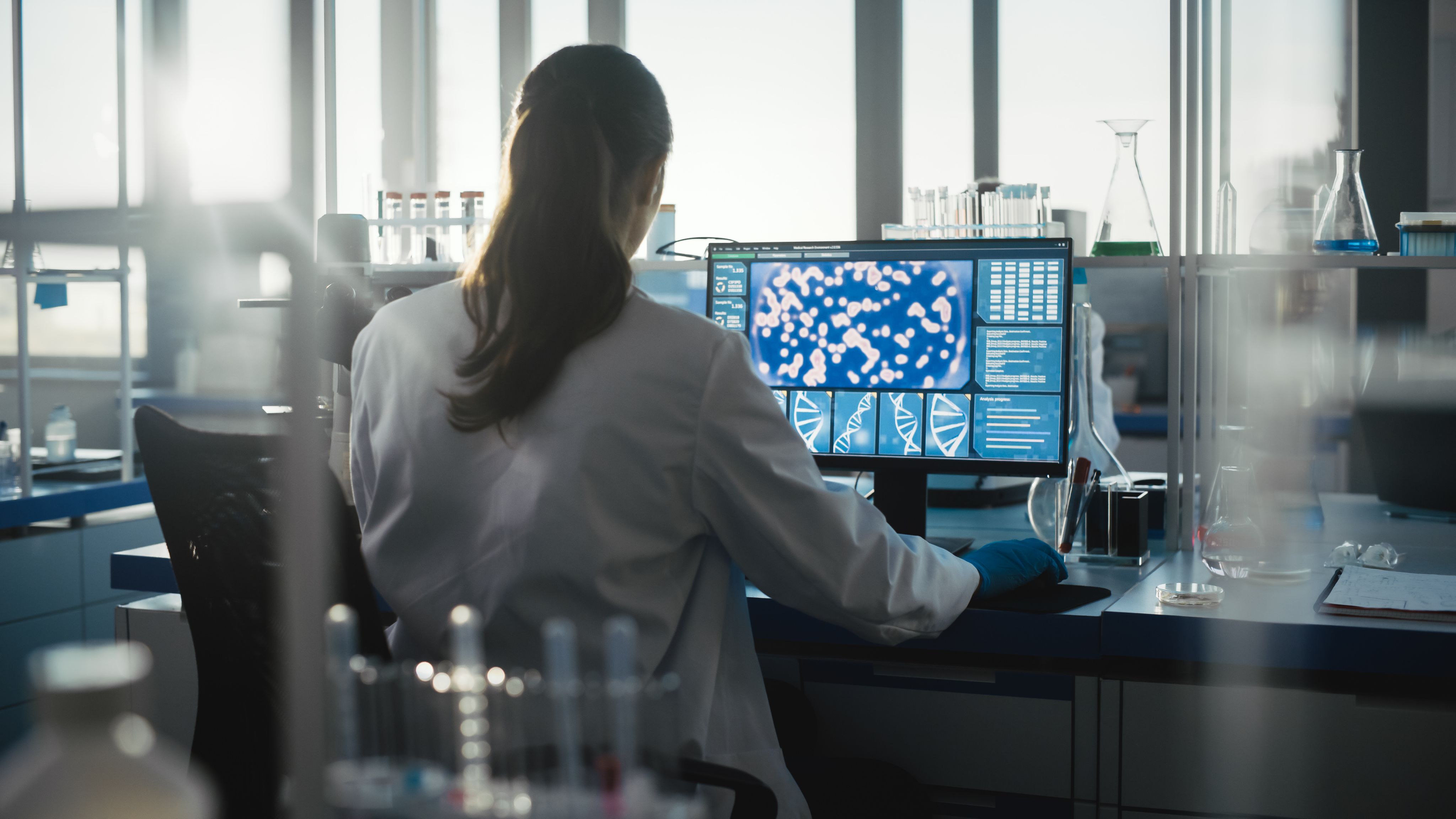 Medical science laboratory with a doctor looking at a computer screen.