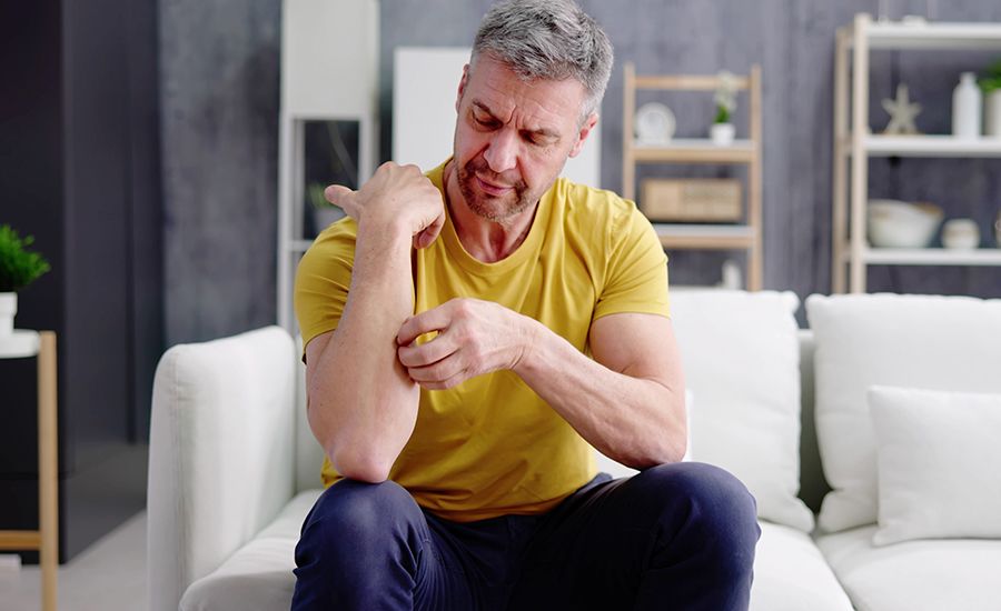 A man scratching his plaque psoriasis.
