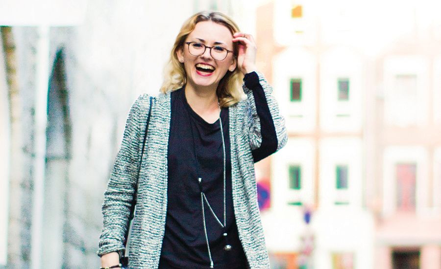 A woman with plaque psoriasis smiling outside.