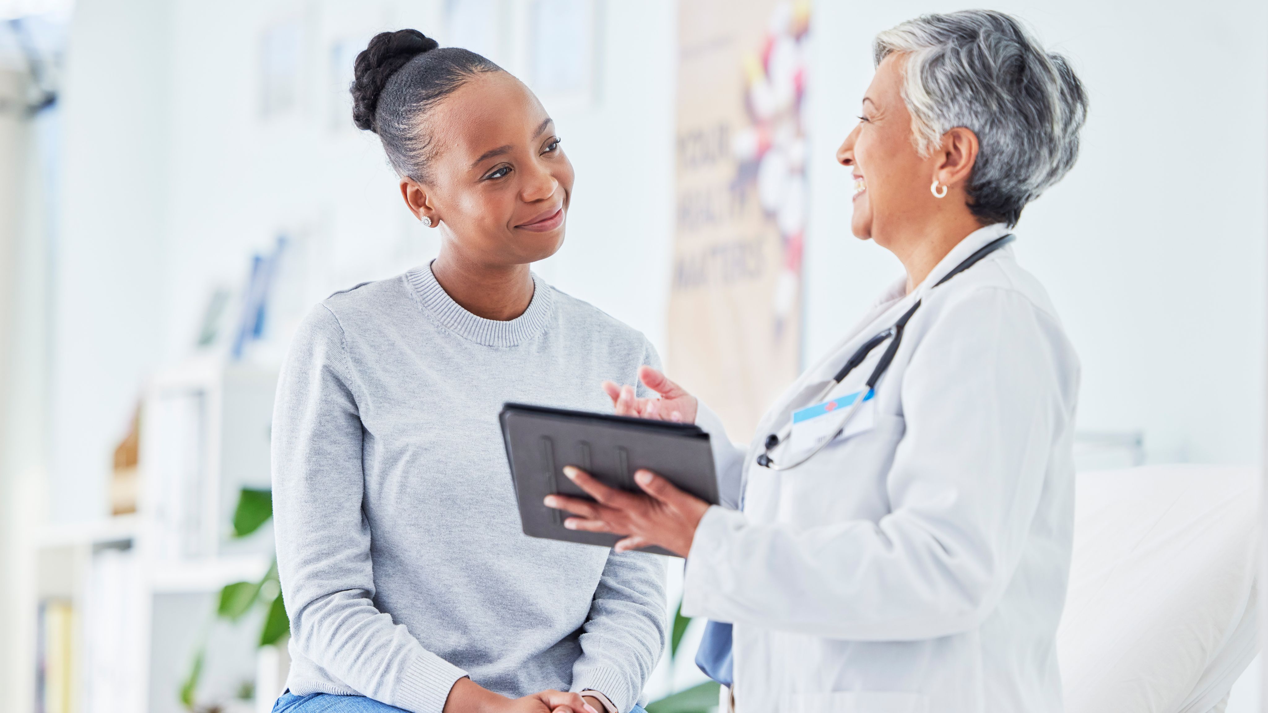 A doctor describing a treatment option to a patient with plaque psoriasis.