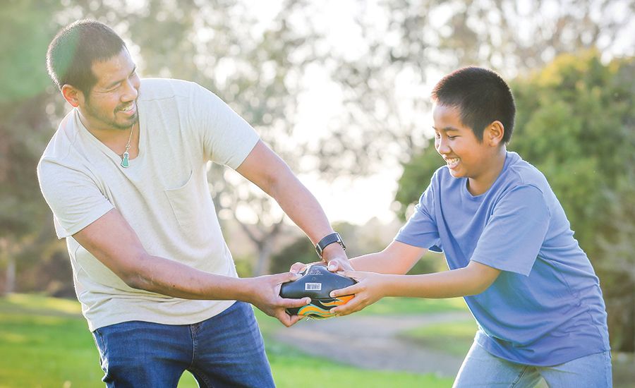 An image of a father and son playing outside.