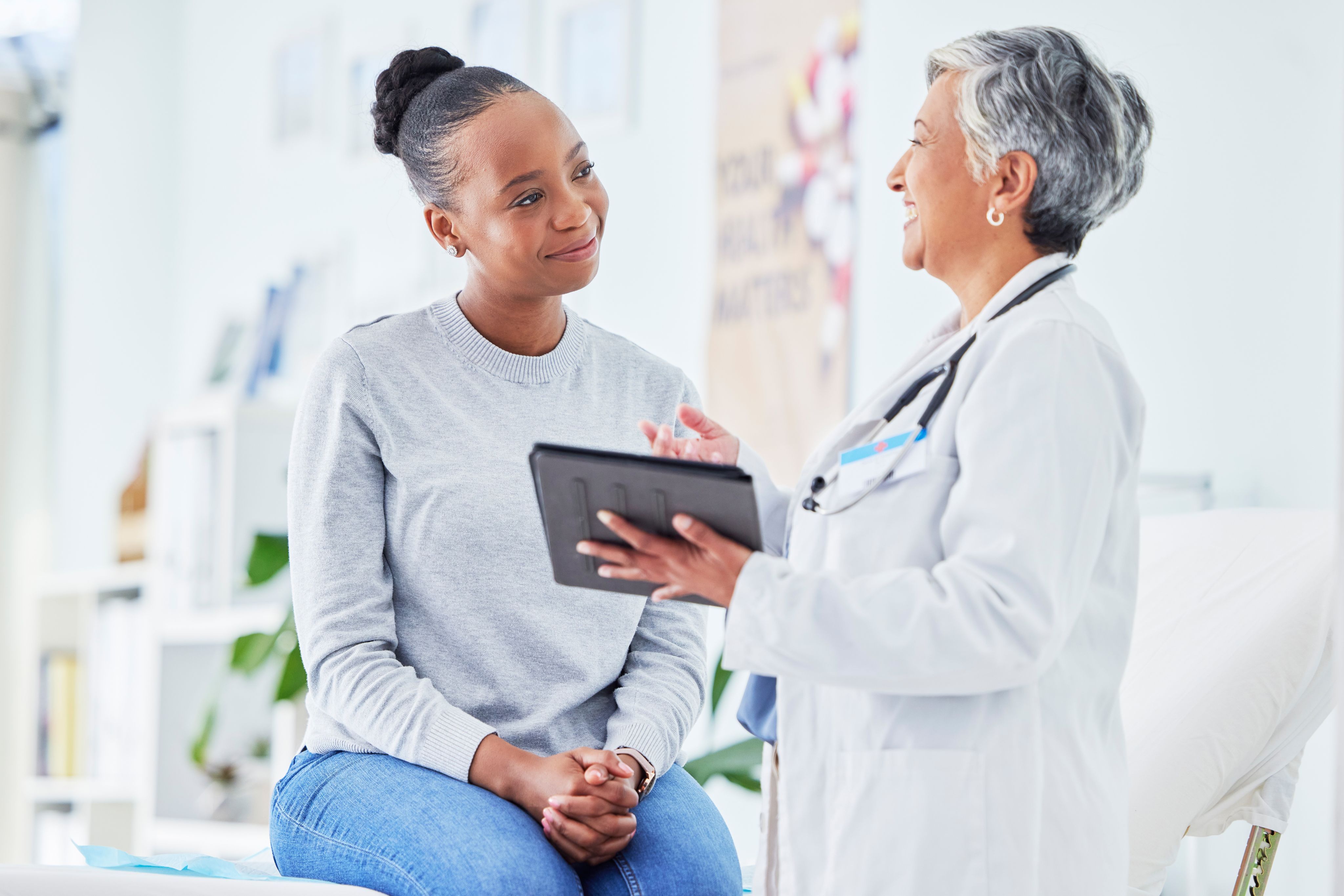 An image of a dermatologist explaining treatment to a woman with plaque psoriasis.