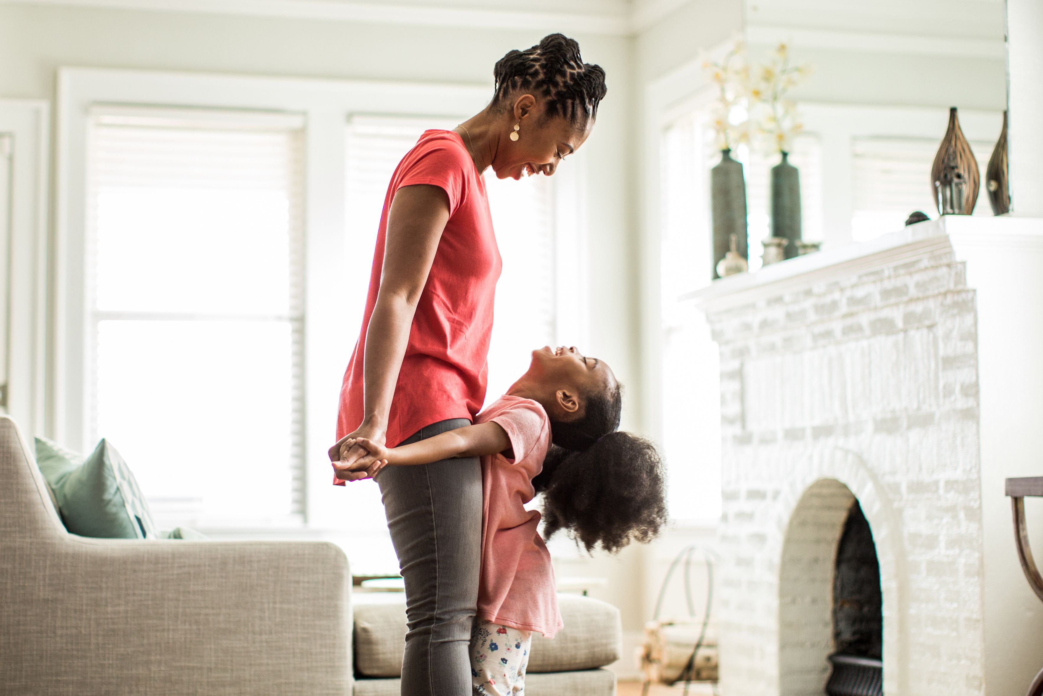 A woman with plaque psoriasis smiling inside with her daughter.