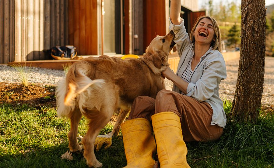 An image of a woman with graves disease smiling with her dog outside.