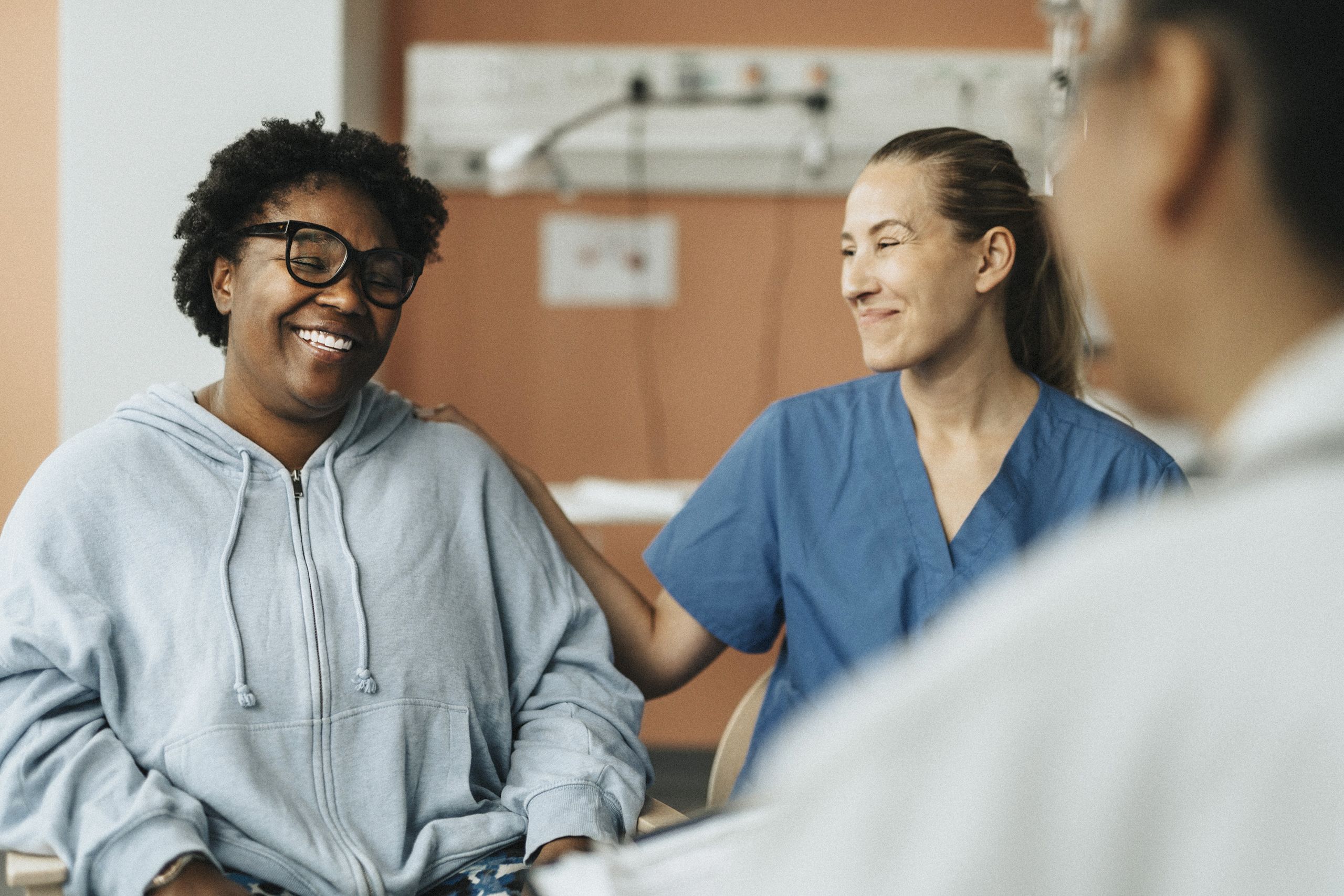 An image of a woman with graves disease smiling and speaking with her doctor.